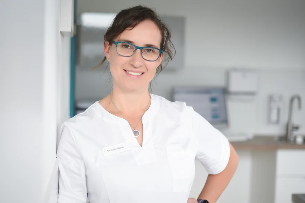 Porträt Dr. Katja Häusler, Inhaberin der Kleintierpraxis Cremlingen, lächelnd mit blauer Brille.